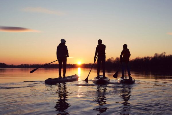 Groep vrienden supt op het water